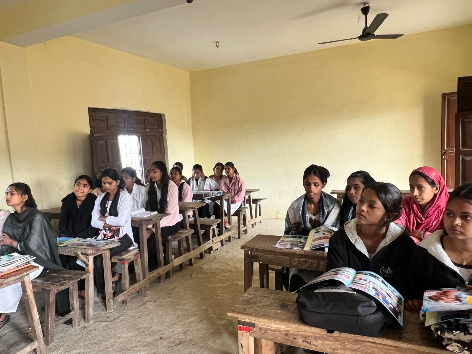 Girl students of varied ages attending a session in a village school