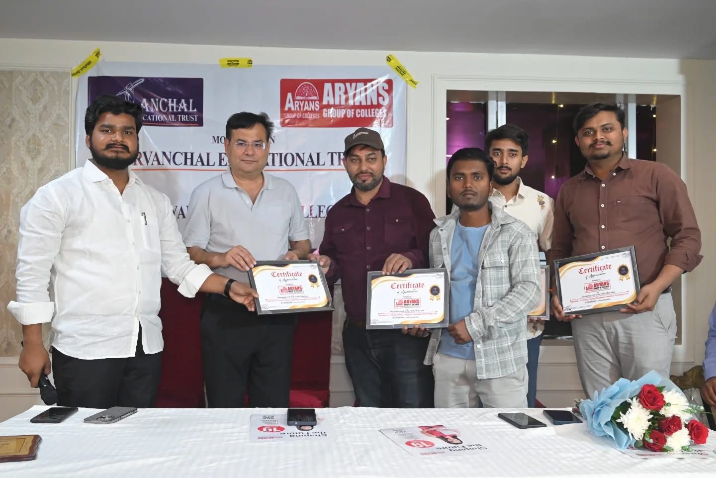 Certificate of appreciation handover with Purvanchal Educational Trust and Aryans Group of Colleges banners