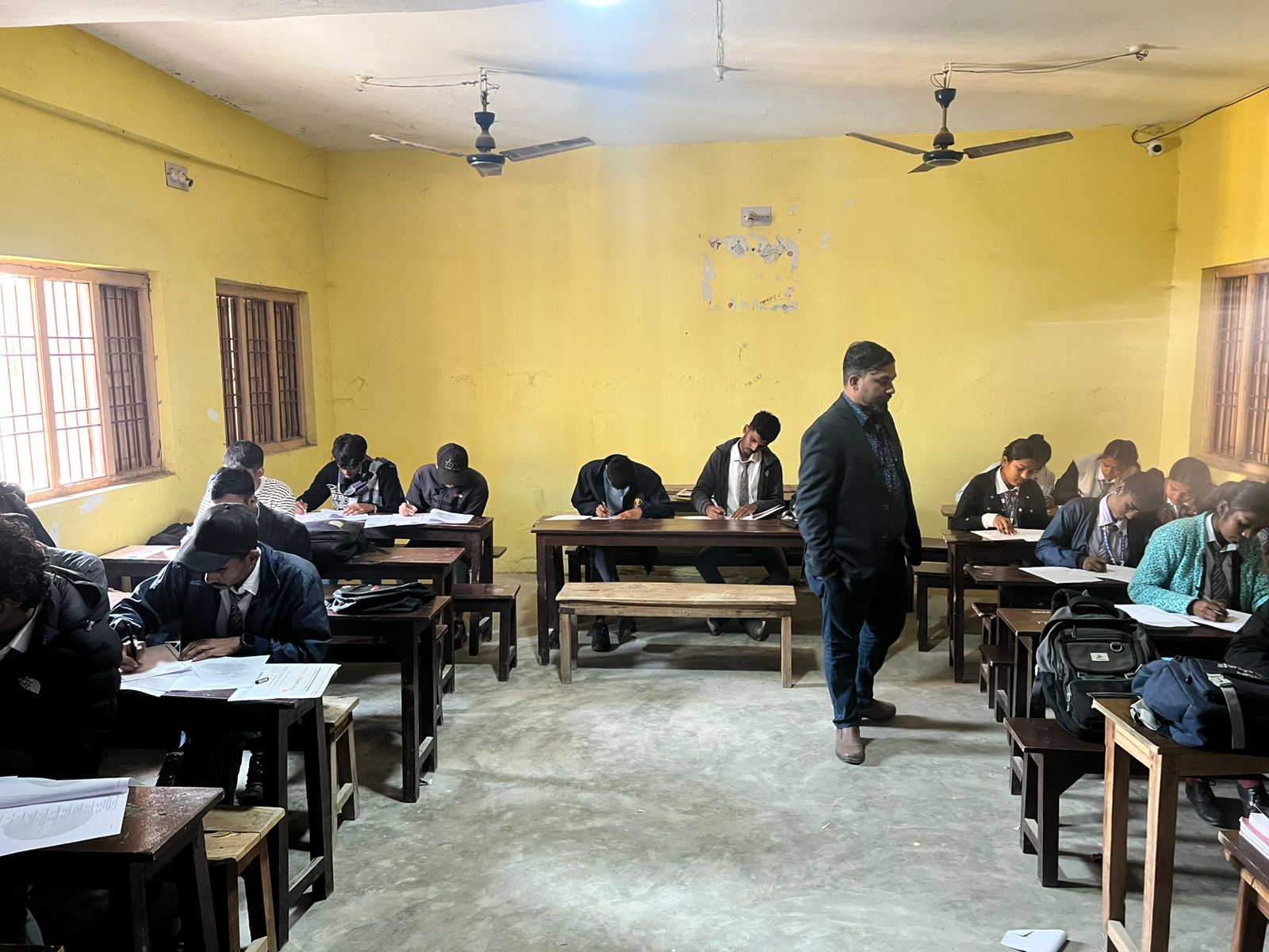 Yellow classroom — students writing scholarship assessment papers