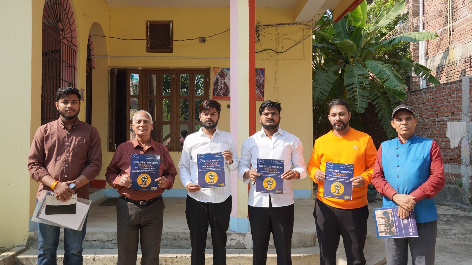 Chhaya Mithila Foundation team standing outside the Janakpur office holding Mission Prayas posters